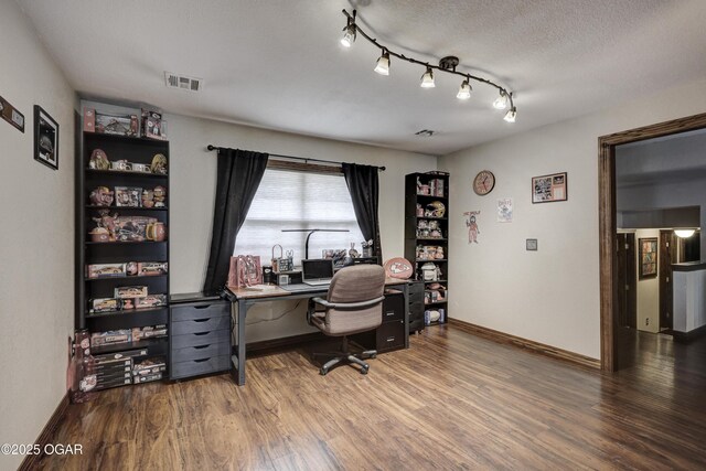 office with baseboards, a textured ceiling, visible vents, track lighting, and wood finished floors