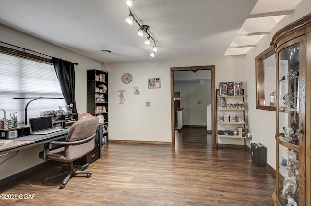 home office featuring baseboards, a textured ceiling, light wood-type flooring, and rail lighting