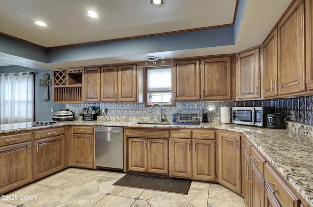 kitchen with a sink, brown cabinets, stainless steel appliances, and tasteful backsplash