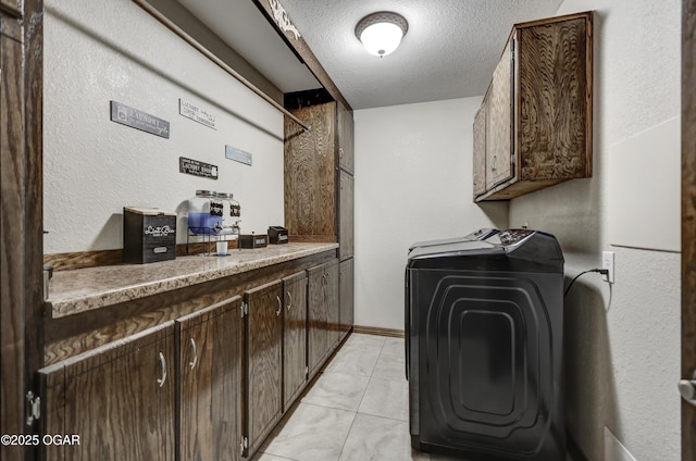 laundry room featuring marble finish floor, independent washer and dryer, cabinet space, and a textured ceiling