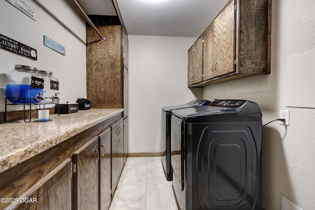 washroom with a textured ceiling, baseboards, independent washer and dryer, cabinet space, and a textured wall