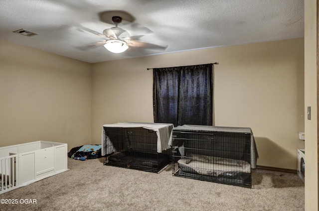 carpeted bedroom with a textured ceiling, visible vents, and a ceiling fan