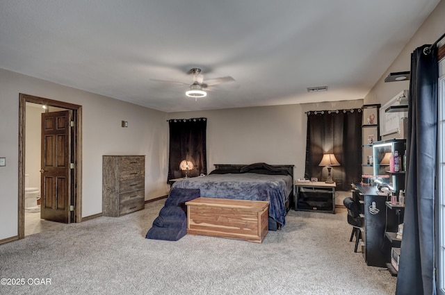 carpeted bedroom featuring baseboards, visible vents, ceiling fan, and ensuite bath