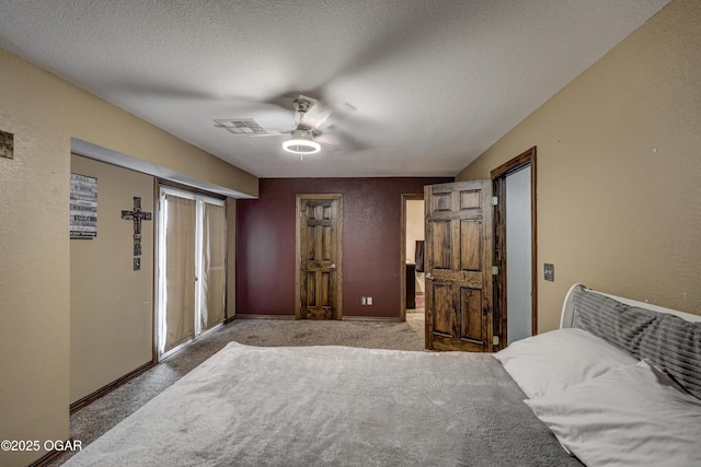 bedroom with a textured wall, baseboards, a textured ceiling, carpet floors, and visible vents