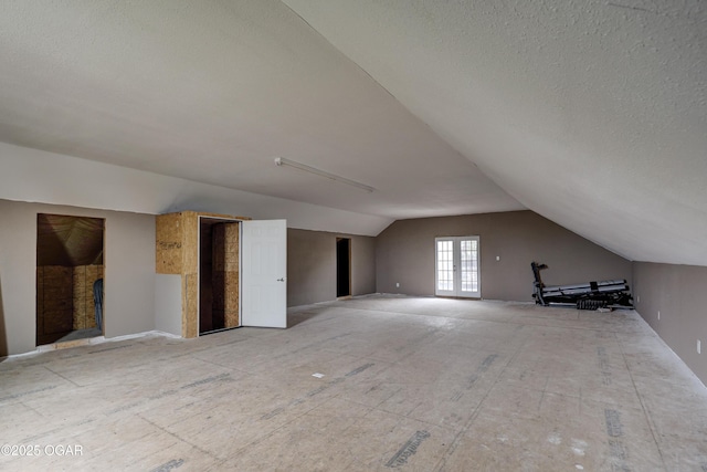 additional living space with lofted ceiling and a textured ceiling