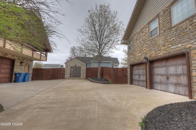 view of yard with fence, driveway, and an attached garage