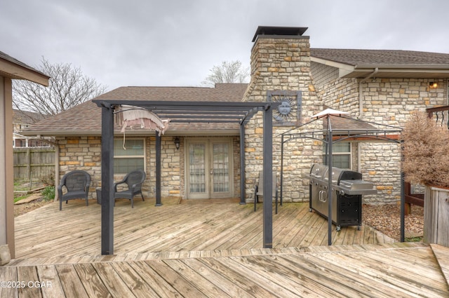 wooden terrace with grilling area, fence, and french doors