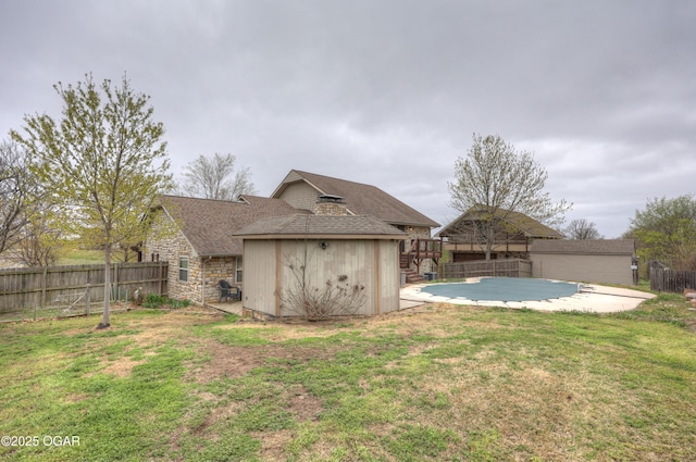 view of yard featuring a fenced backyard, an outdoor structure, a storage shed, and a patio area