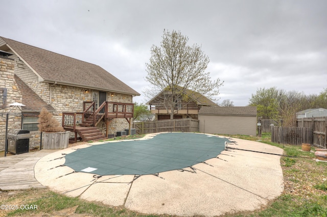 view of swimming pool featuring fence, a patio, a grill, a wooden deck, and a fenced in pool