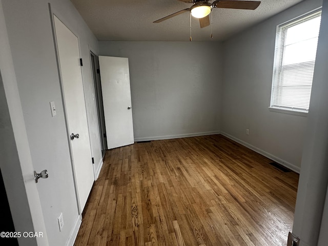 1515 S Missouri Ave, Joplin, MO 64804 - unfurnished bedroom featuring baseboards, visible vents, wood finished floors, and a textured ceiling