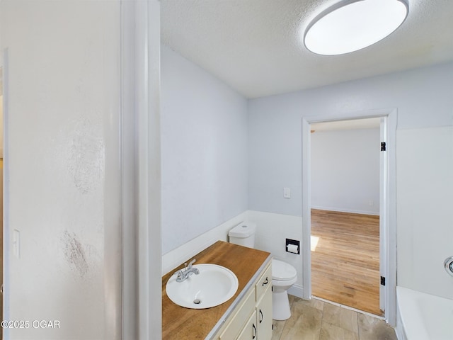 1515 S Missouri Ave, Joplin, MO 64804 - bathroom with tile walls, a textured ceiling, toilet, vanity, and wainscoting
