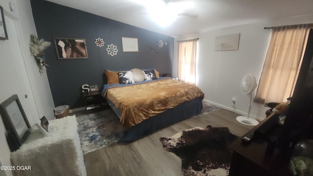 bedroom with baseboards and wood finished floors