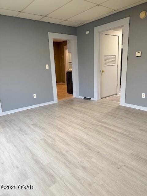 201 N Georgia St, Pittsburg, KS 66762 - empty room featuring a drop ceiling, baseboards, light wood finished floors, and a smoke detector