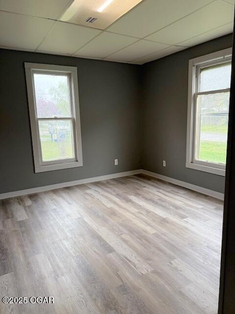 201 N Georgia St, Pittsburg, KS 66762 - unfurnished room featuring a drop ceiling, light wood-type flooring, and baseboards