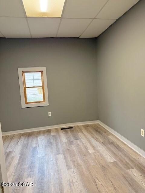 201 N Georgia St, Pittsburg, KS 66762 - unfurnished room featuring a paneled ceiling, light wood-style floors, and baseboards