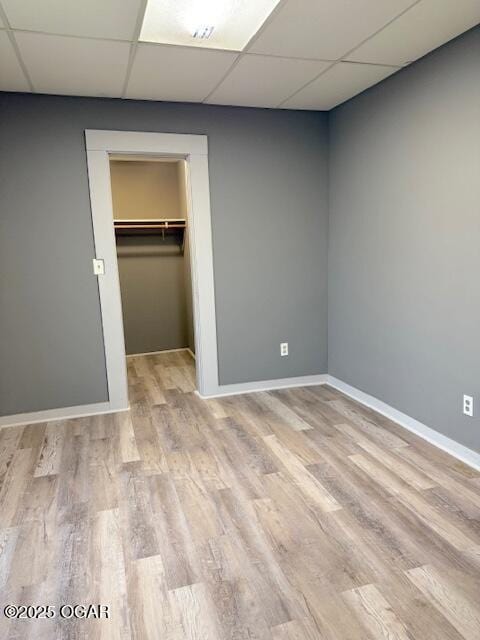 201 N Georgia St, Pittsburg, KS 66762 - unfurnished bedroom featuring a drop ceiling, baseboards, wood finished floors, a closet, and a spacious closet