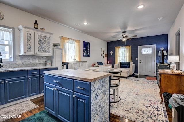 1831 Annie Baxter Ave, Joplin, MO 64804 - kitchen featuring dark wood finished floors, wood counters, blue cabinets, ceiling fan, and a sink