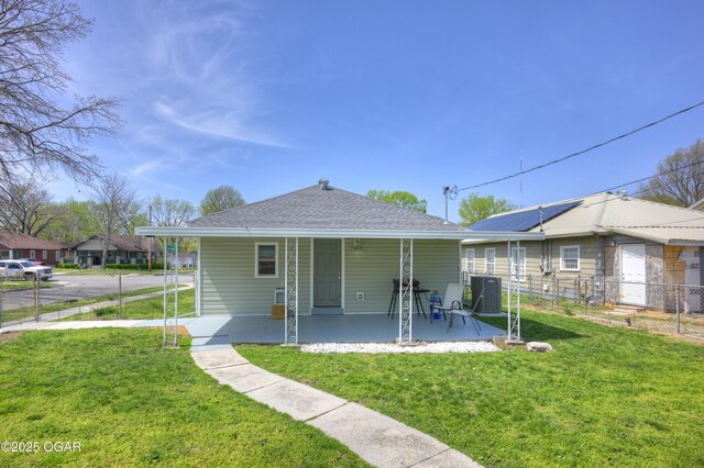1831 Annie Baxter Ave, Joplin, MO 64804 - rear view of house featuring a lawn, central AC unit, fence, a shingled roof, and driveway
