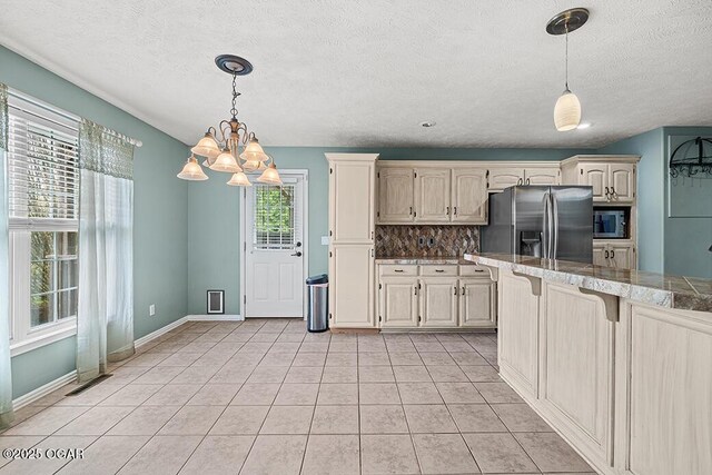 3826 W Randall St, Battlefield, MO 65619 - kitchen with an inviting chandelier, a kitchen bar, light tile patterned flooring, stainless steel appliances, and decorative backsplash