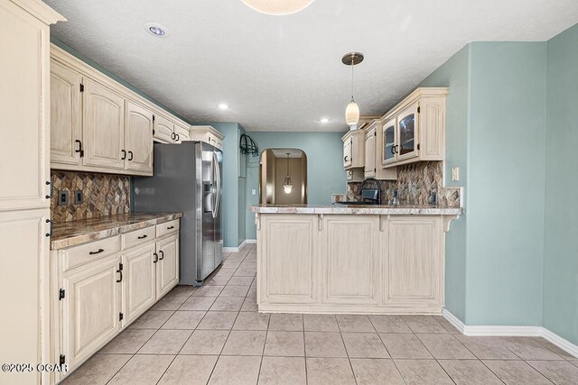 3826 W Randall St, Battlefield, MO 65619 - kitchen featuring baseboards, a peninsula, glass insert cabinets, light tile patterned floors, and cream cabinetry