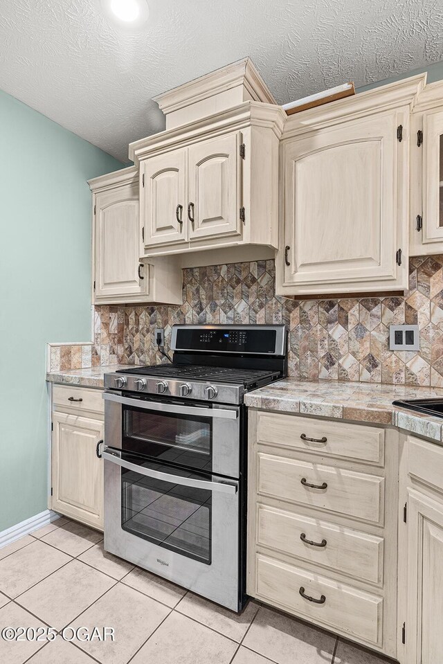 3826 W Randall St, Battlefield, MO 65619 - kitchen with tasteful backsplash, a textured ceiling, light tile patterned flooring, light countertops, and range with two ovens