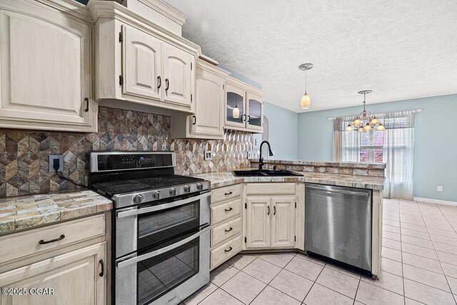 3826 W Randall St, Battlefield, MO 65619 - kitchen featuring an inviting chandelier, a peninsula, light tile patterned flooring, a sink, and stainless steel appliances