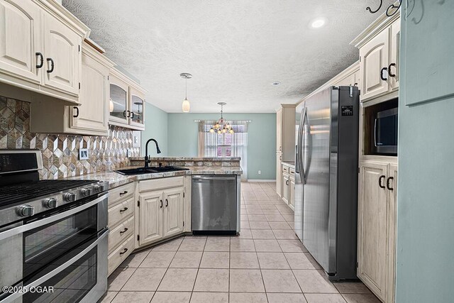 3826 W Randall St, Battlefield, MO 65619 - kitchen with a chandelier, a peninsula, light tile patterned floors, appliances with stainless steel finishes, and a sink