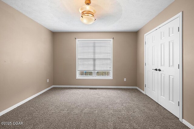 3826 W Randall St, Battlefield, MO 65619 - unfurnished bedroom featuring baseboards, carpet, and a textured ceiling