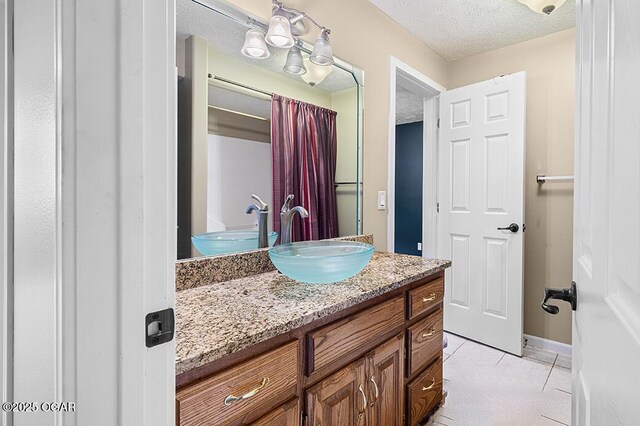 3826 W Randall St, Battlefield, MO 65619 - bathroom featuring tile patterned floors, vanity, a textured ceiling, and baseboards