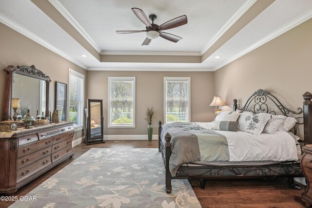 1624 Liam St, Carthage, MO 64836 - bedroom featuring baseboards, ornamental molding, a ceiling fan, a tray ceiling, and dark wood finished floors