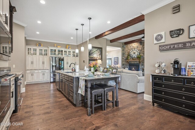 1624 Liam St, Carthage, MO 64836 - kitchen featuring glass insert cabinets, a sink, appliances with stainless steel finishes, a fireplace, and light stone counters
