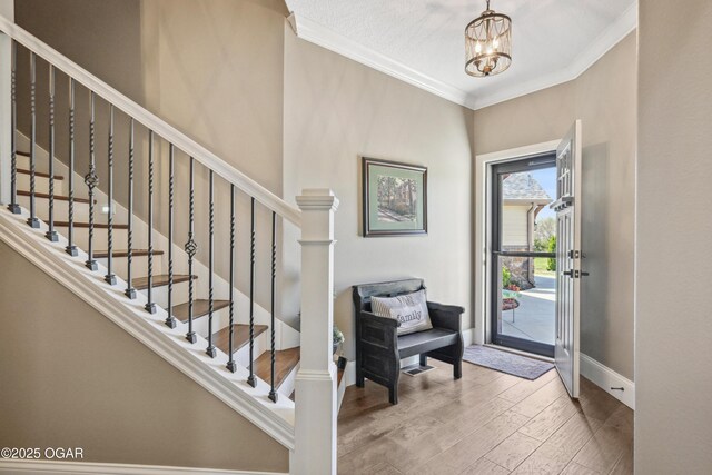 1624 Liam St, Carthage, MO 64836 - foyer entrance with baseboards, a notable chandelier, crown molding, wood finished floors, and stairs