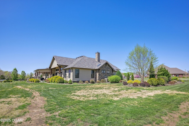 1624 Liam St, Carthage, MO 64836 - view of home's exterior with stone siding, a chimney, and a lawn