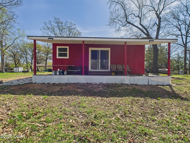 back of property featuring a yard and an outdoor structure