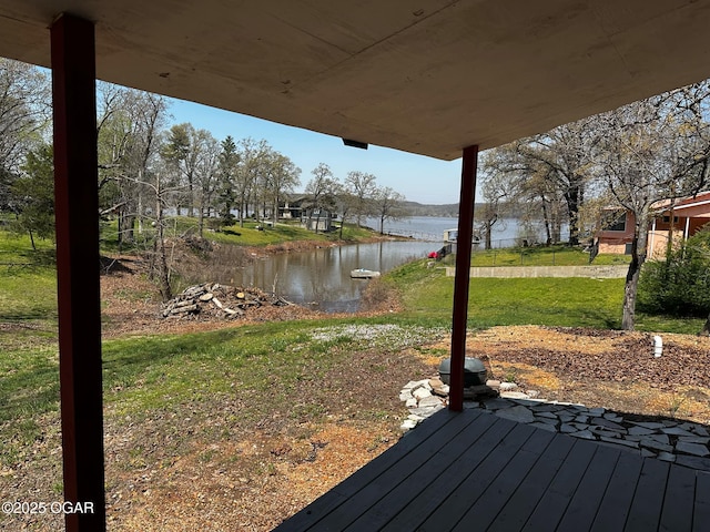 wooden terrace with a yard and a water view