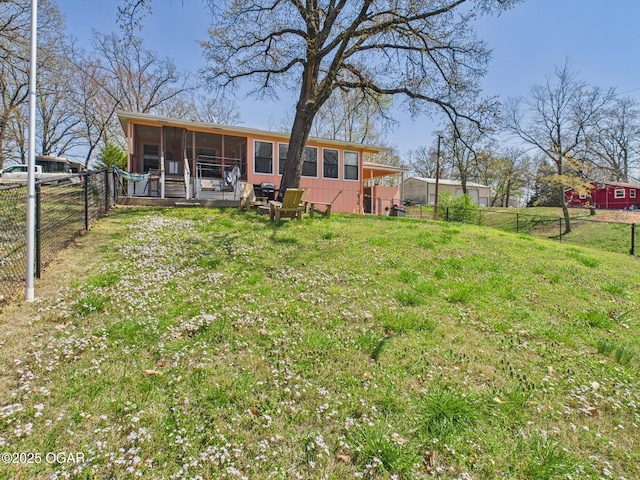 view of yard featuring a sunroom and a fenced backyard