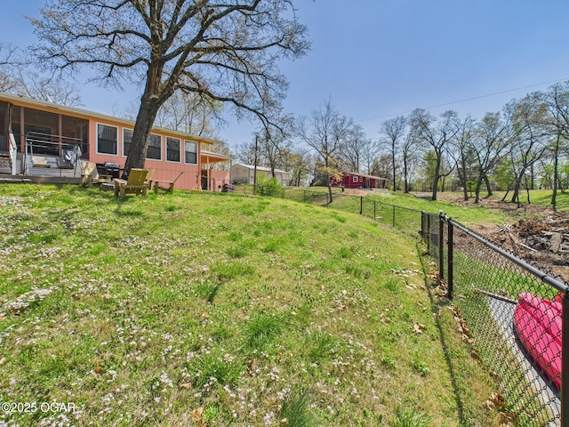 view of yard featuring fence and a sunroom