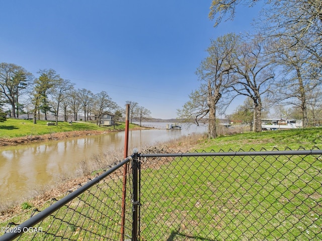 view of yard featuring a water view, fence, and a gate