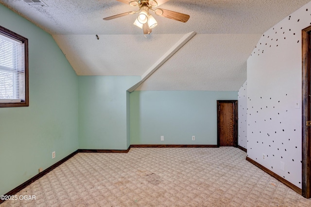 additional living space with baseboards, ceiling fan, a textured ceiling, carpet floors, and vaulted ceiling
