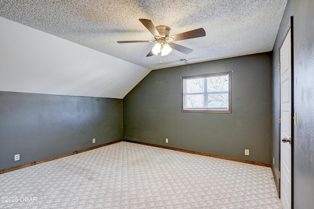 additional living space featuring lofted ceiling, baseboards, a textured ceiling, carpet floors, and ceiling fan