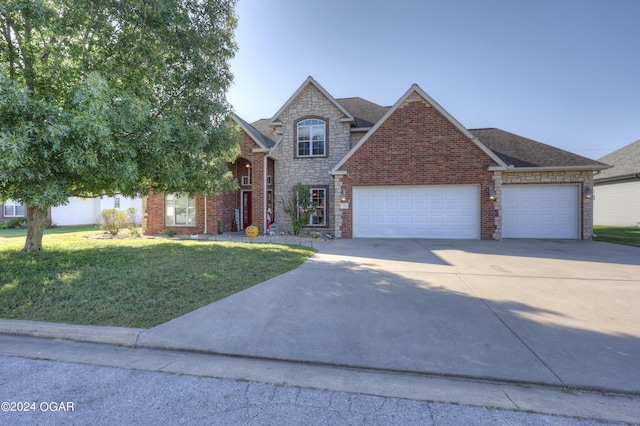 view of front of house with a garage, driveway, stone siding, and a front lawn