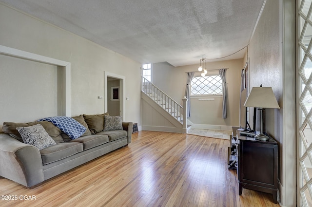 426 N Byers Ave, Joplin, MO 64801 - living area with a textured ceiling, wood finished floors, baseboards, and stairway