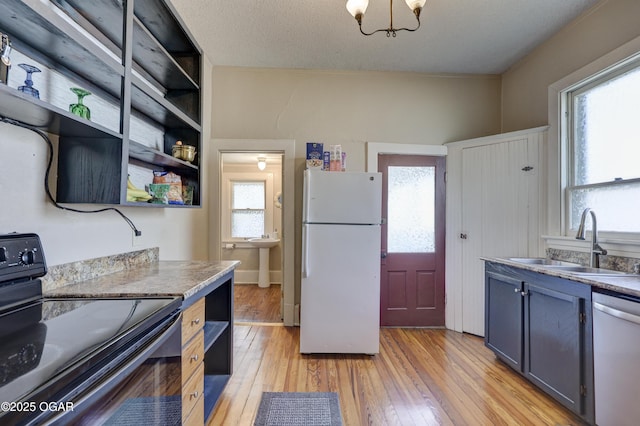 426 N Byers Ave, Joplin, MO 64801 - kitchen with freestanding refrigerator, stainless steel dishwasher, open shelves, a sink, and black / electric stove