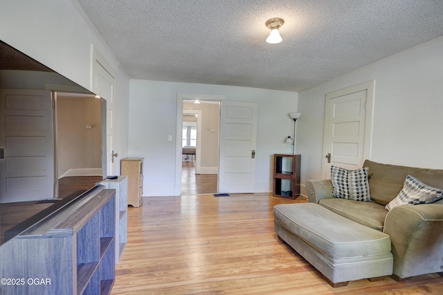 426 N Byers Ave, Joplin, MO 64801 - living area with baseboards, light wood finished floors, and a textured ceiling