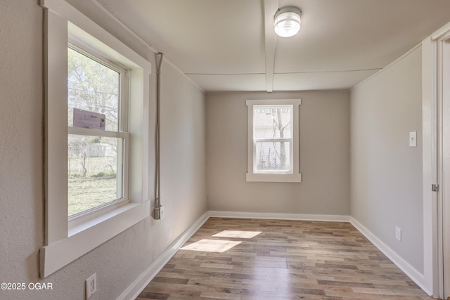 unfurnished dining area with wood finished floors and baseboards