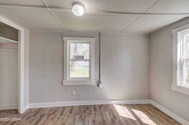 interior space featuring plenty of natural light, baseboards, and wood finished floors