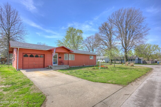 ranch-style house with a front yard, a garage, and concrete driveway