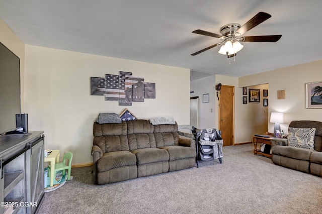carpeted living room featuring baseboards and a ceiling fan