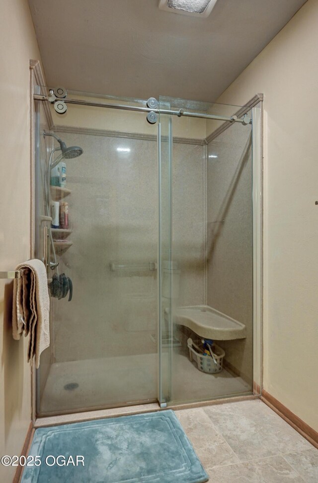 bathroom with baseboards and a stall shower