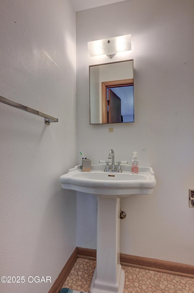 bathroom with a sink and baseboards
